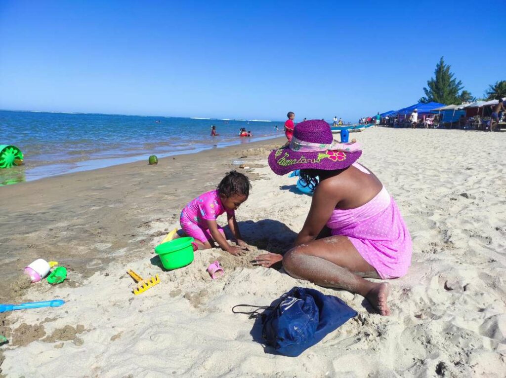 Mère et fille sur la plage de Foulpointe : rires et jeux de sable créent des souvenirs inoubliables.